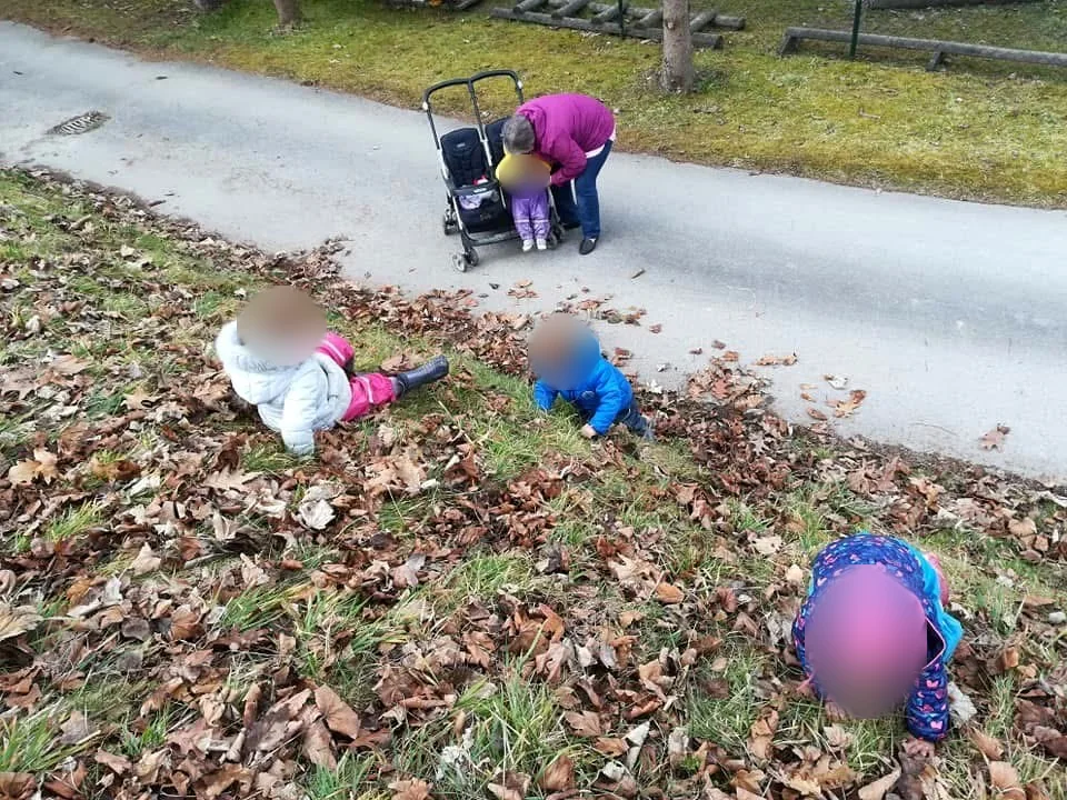 Otroci med raziskovanjem jesenskega listja na vrtu